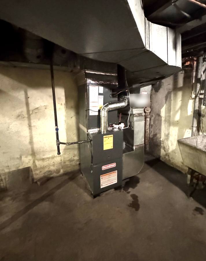 New Goodman furnace installed with new flue piping in a cleared basement corner