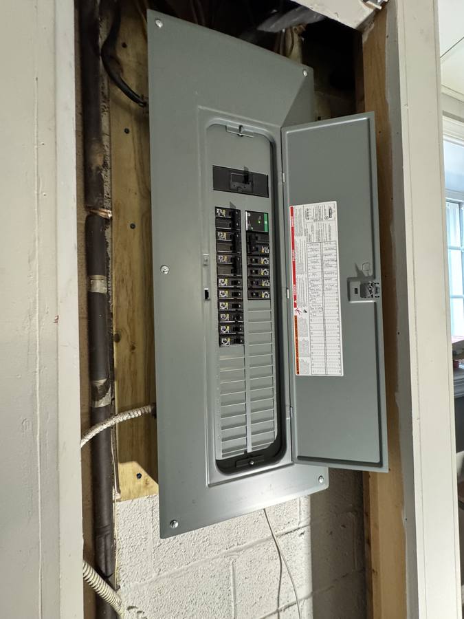 New Square D electrical panel with breakers installed and a hand-labelled circuit directory